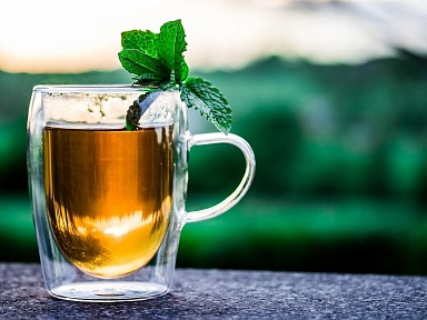 Herbata oolong, tradycyjnie pita w Chinach, zyskuje coraz większą popularność także w Polsce. Jej wyjątkowy proces produkcji sprawia, że plasuje się pomiędzy zieloną a czarną herbatą, a naukowcy przyglądają się jej potencjalnym korzyściom zdrowotnym.  Jak podaje Medonet oolong powstaje z liści Camellia sinensis — tej samej rośliny, z której wytwarza się zarówno zieloną, jak i czarną herbatę. Różnica polega na stopniu utlenienia liści. W przypadku zielonej herbaty liście nie są utleniane, natomiast czarna herbata przechodzi pełny proces utleniania. Oolong znajduje się pośrodku tej skali — liście są częściowo utleniane, co nadaje naparowi charakterystyczny smak oraz aromat.  W składzie herbaty oolong można znaleźć witaminy, minerały oraz antyoksydanty. W jednej filiżance znajduje się niewielka ilość wapnia, magnezu i potasu, a także około 38 mg kofeiny — to więcej niż w zielonej herbacie, która zawiera średnio 29 mg. Najważniejsze przeciwutleniacze obecne w oolong to polifenole, takie jak teaflawiny, tearubiginy oraz EGCG, które odpowiadają za prozdrowotne działanie napoju. Oolong zawiera również L-teaninę, aminokwas wspierający relaksację i koncentrację.  Naukowcy analizują wpływ oolong na poziom cukru we krwi i ryzyko cukrzycy typu 2. Polifenole zawarte w herbacie mogą wspierać kontrolę glikemii i zmniejszać ryzyko rozwoju tej choroby. Badania sugerują, że regularne spożywanie herbaty może poprawiać wrażliwość na insulinę i redukować stany zapalne, jednak w przypadku oolong wyniki nie są tak jednoznaczne jak w przypadku zielonej lub czarnej herbaty. Część analiz wykazała pozytywne efekty, podczas gdy inne nie potwierdziły związku. Wskazuje się na potrzebę dalszych badań.  Medonet wskazuje, że regularne picie herbaty oolong może przynosić korzyści dla serca. Wyniki dużych badań pokazują, że osoby spożywające co najmniej 240 ml tego naparu dziennie mają nawet o 61 proc. niższe ryzyko chorób serca. Oolong może także przyczyniać się do obniżenia ciśnienia krwi i poziomu cholesterolu, a także zmniejszać ryzyko udaru. Warto jednak pamiętać o obecności kofeiny, która, choć w mniejszych ilościach niż w kawie, u niektórych osób może powodować wzrost ciśnienia.  Herbata oolong od dawna bywa kojarzona ze wsparciem w odchudzaniu. Polifenole i kofeina mogą hamować określone enzymy, zwiększać spalanie kalorii oraz wspierać redukcję tkanki tłuszczowej. Badania na zwierzętach wykazały, że ekstrakty z oolong zwiększają utlenianie tłuszczu, jednak w przypadku ludzi potrzeba jeszcze dalszych analiz. Eksperci podkreślają, że samo picie herbaty nie zastąpi zdrowej diety i aktywności fizycznej.  Oolong może również korzystnie wpływać na funkcje poznawcze, pamięć i nastrój. Kofeina stymuluje wydzielanie noradrenaliny i dopaminy, a L-teanina wspomaga koncentrację i łagodzi niepokój. Badania sugerują, że regularne spożywanie herbaty wiąże się z niższym ryzykiem zaburzeń funkcji poznawczych, zwłaszcza u osób starszych.  Polifenole obecne w oolong mogą pomagać w ochronie przed rozwojem niektórych nowotworów, spowalniając tempo podziałów komórek nowotworowych. Najwięcej danych dotyczy zielonej i czarnej herbaty, jednak jako że oolong znajduje się pomiędzy nimi, można przypuszczać, że wykazuje podobne właściwości. Wskazuje się jednak na konieczność przeprowadzenia dalszych badań skupionych wyłącznie na oolong.  Picie herbaty oolong może wspierać zdrowie kości i zębów. Wyniki badań wykazały, że osoby regularnie spożywające herbatę mają wyższą gęstość mineralną kości i mniejsze ryzyko złamań. Napar ten może także pomagać w utrzymaniu zdrowia jamy ustnej, zmniejszając ilość płytki nazębnej oraz zapobiegając zapaleniu dziąseł.  Ciekawostką jest potencjalny wpływ herbaty oolong na łagodzenie objawów atopowego zapalenia skóry. Wyniki jednego z badań wykazały, że picie litra oolong dziennie przez osoby z ciężką egzemą przyniosło znaczną poprawę już po jednym lub dwóch tygodniach, a efekt utrzymywał się nawet kilka miesięcy. Wyniki te są obiecujące, jednak wymagają potwierdzenia w większych badaniach.  Herbata oolong jest uznawana za bezpieczną, jednak należy pamiętać o zawartości kofeiny. Jej nadmiar może prowadzić do pobudzenia, bezsenności, bólów głowy czy zaburzeń rytmu serca. Zarówno amerykańska FDA, jak i Europejski Urząd ds. Bezpieczeństwa Żywności uznają do 400 mg kofeiny dziennie za bezpieczną ilość dla dorosłych, co odpowiada sześciu–dziesięciu filiżankom oolong dziennie. Kobiety w ciąży powinny ograniczyć spożycie kofeiny do 200 mg na dobę.  Herbata oolong może być ciekawym wyborem dla osób, które chcą zadbać o zdrowie serca, mózgu, kości i jamy ustnej. Może wspierać odchudzanie, obniżać ryzyko cukrzycy typu 2 oraz niektórych nowotworów. Zawiera mniej kofeiny niż kawa, dlatego może być odpowiednia także dla osób wrażliwych na ten składnik. Choć nie wszystkie właściwości oolong zostały jednoznacznie potwierdzone naukowo, regularne spożywanie tej herbaty może być wartościowym elementem zdrowego stylu życia.